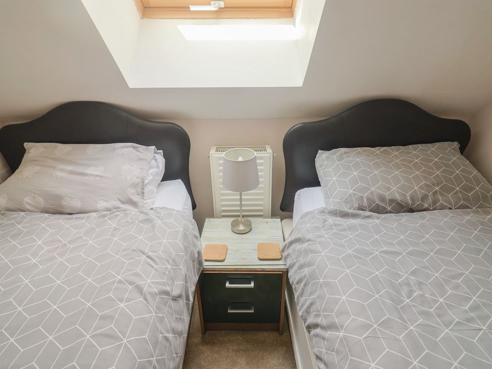 A bedroom with two beds and a nightstand at Beck House in Weymouth