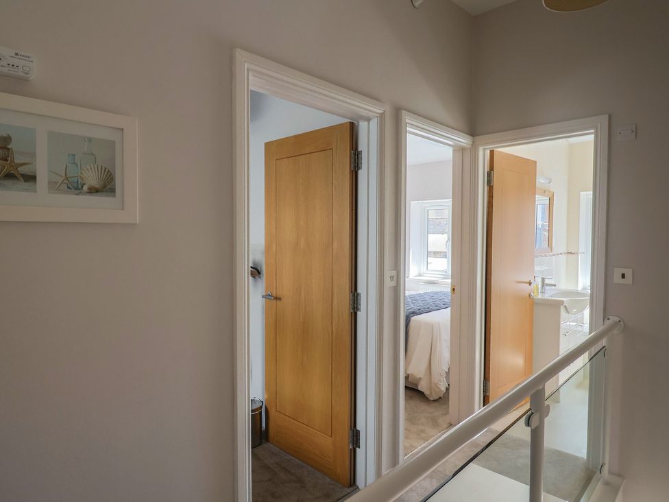 A hallway with multiple doors and a decorative frame at Beck House in Weymouth