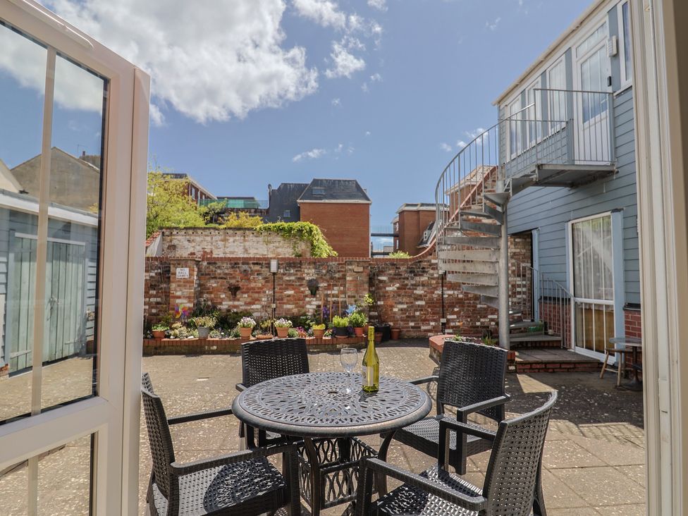 A courtyard with a table and chairs at Beck House in Weymouth