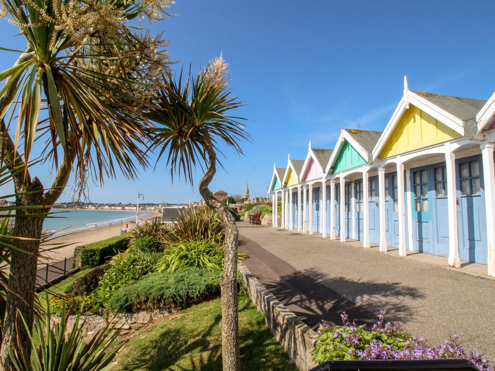 Beach huts along a sandy shore at Beck House in Weymouth