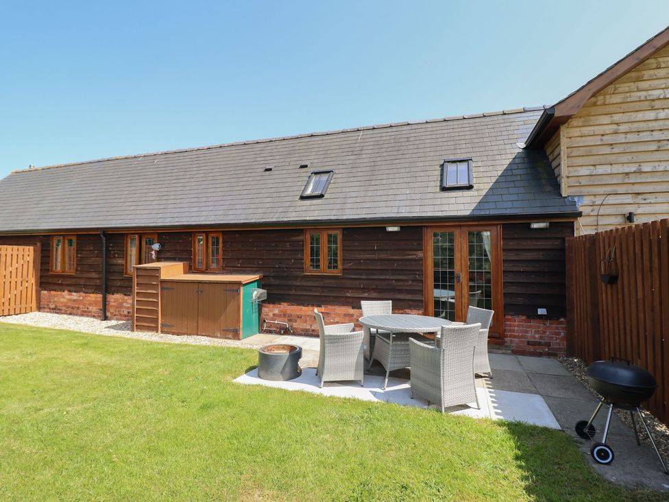 An outdoor seating area with a table and chairs at Ysgubor Fachwen Newtown