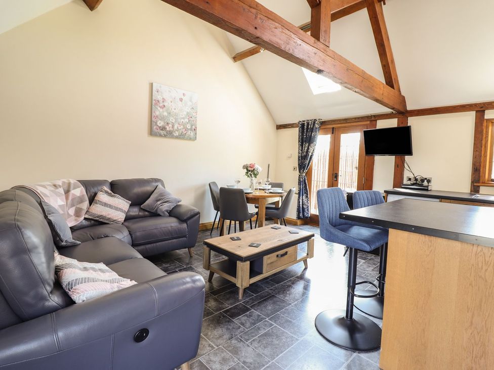 A living room with a sofa and coffee table at Ysgubor Fachwen in Newtown