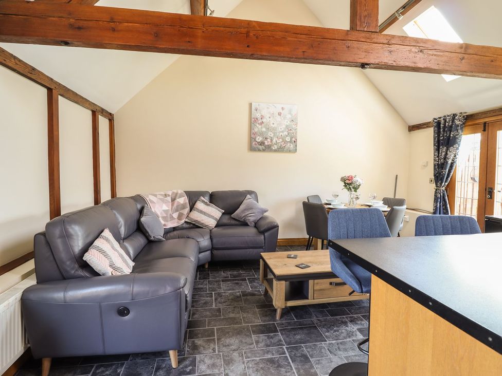 A living room with a sofa and dining table at Ysgubor Fachwen in Newtown