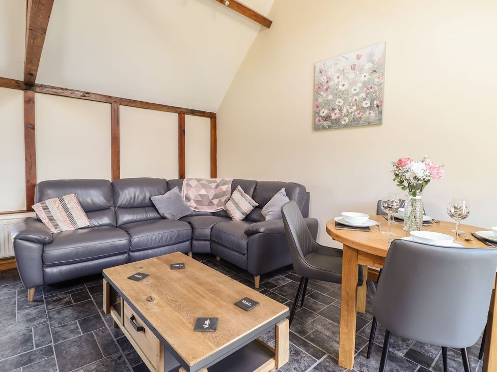 A living room with a sofa and dining table at Ysgubor Fachwen in Newtown