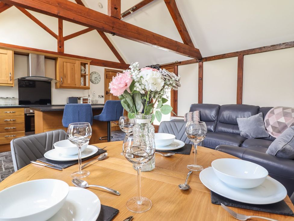 A dining room with a table set for dinner at Ysgubor Fachwen in Newtown