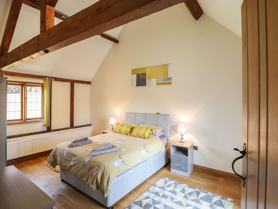 A bedroom with a bed and bedside table at Ysgubor Fachwen in Newtown