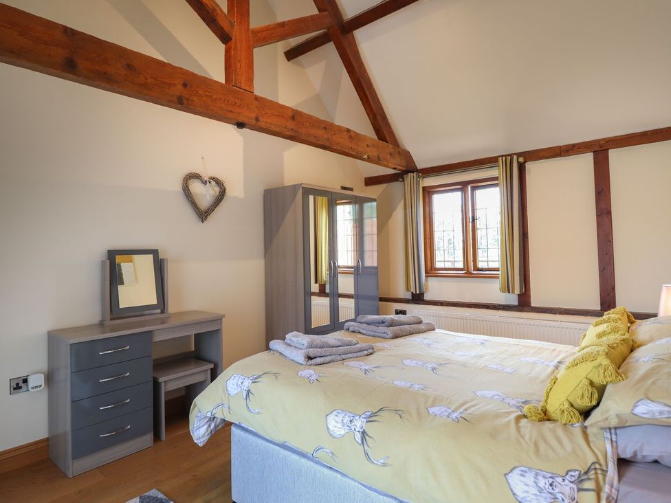 A bedroom with a bed and wardrobe at Ysgubor Fachwen Newtown