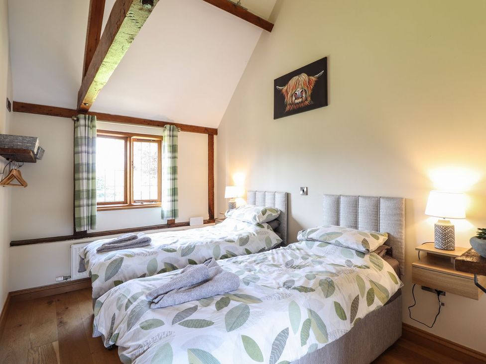 A bedroom with two beds and a window at Ysgubor Fachwen in Newtown