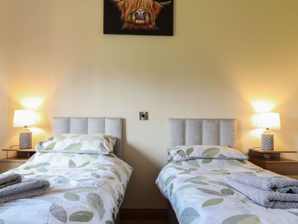 A bedroom with two beds and lamps at Ysgubor Fachwen in Newtown