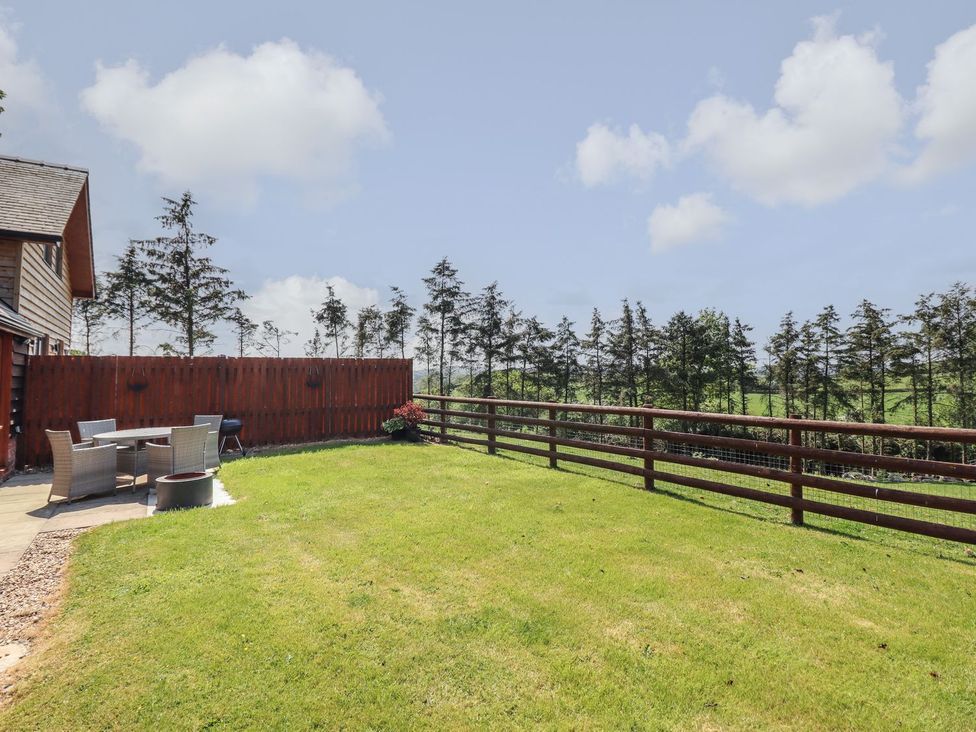 A garden with a seating area and trees at Ysgubor Fachwen in Newtown