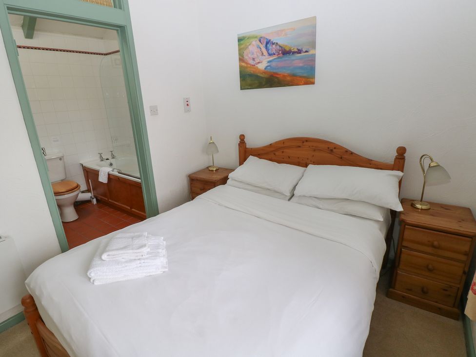 A bedroom with a bed and adjoining bathroom at Warbler Cottage in Cowbridge