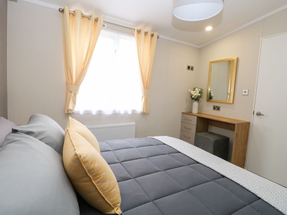 A bedroom with a bed and dressing table at The Honey Pot Retreat in Fritton near Belton, Norfolk