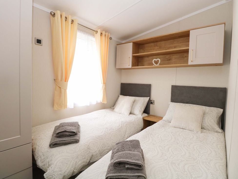 A bedroom with twin beds and shelves at The Honey Pot Retreat in Fritton near Belton, Norfolk