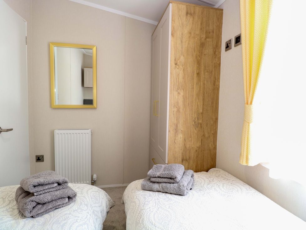 A bedroom with two beds and towels on a bed at The Honey Pot Retreat Fritton near Belton Norfolk