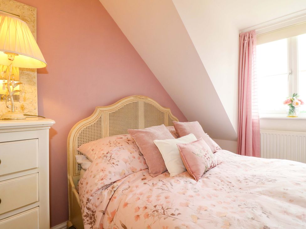 A bedroom with a bed, lamp, and window at 16 Temple Crescent Nuthall