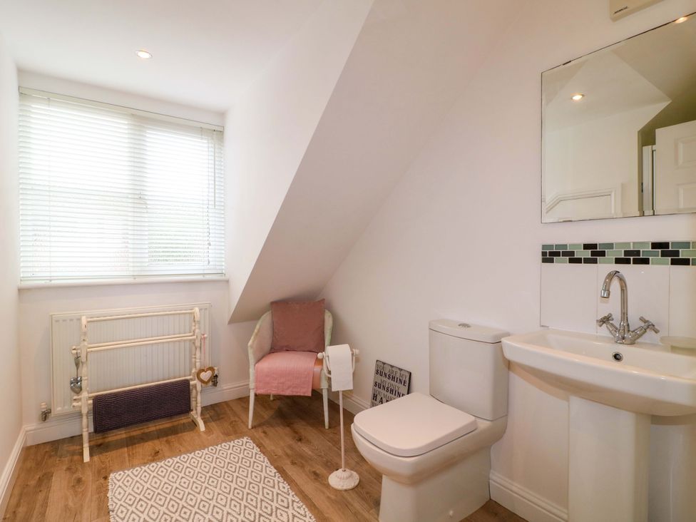 A bathroom with a toilet, sink, and radiator at 16 Temple Crescent Nuthall
