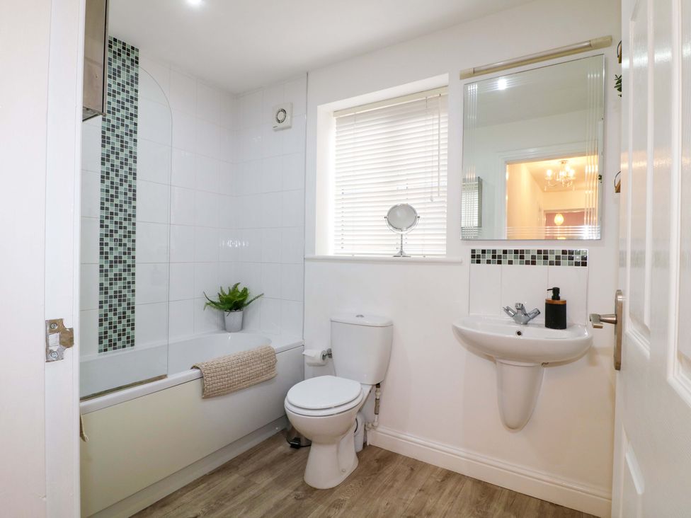 A bathroom with a bath and sink at 16 Temple Crescent Nuthall