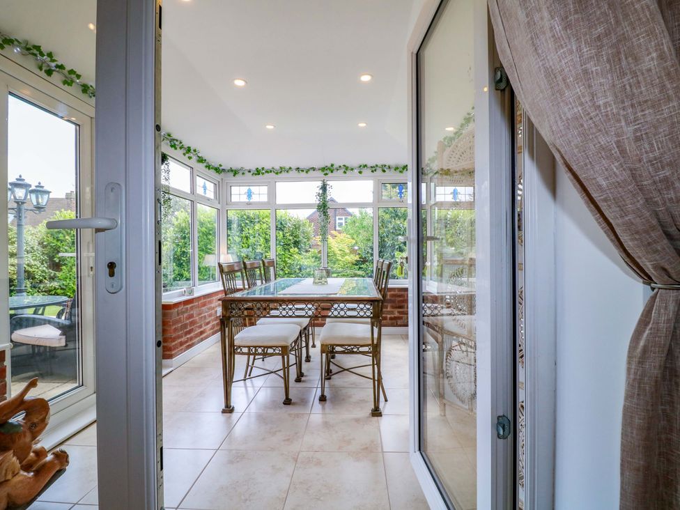 A conservatory with a table and chairs at 16 Temple Crescent Nuthall