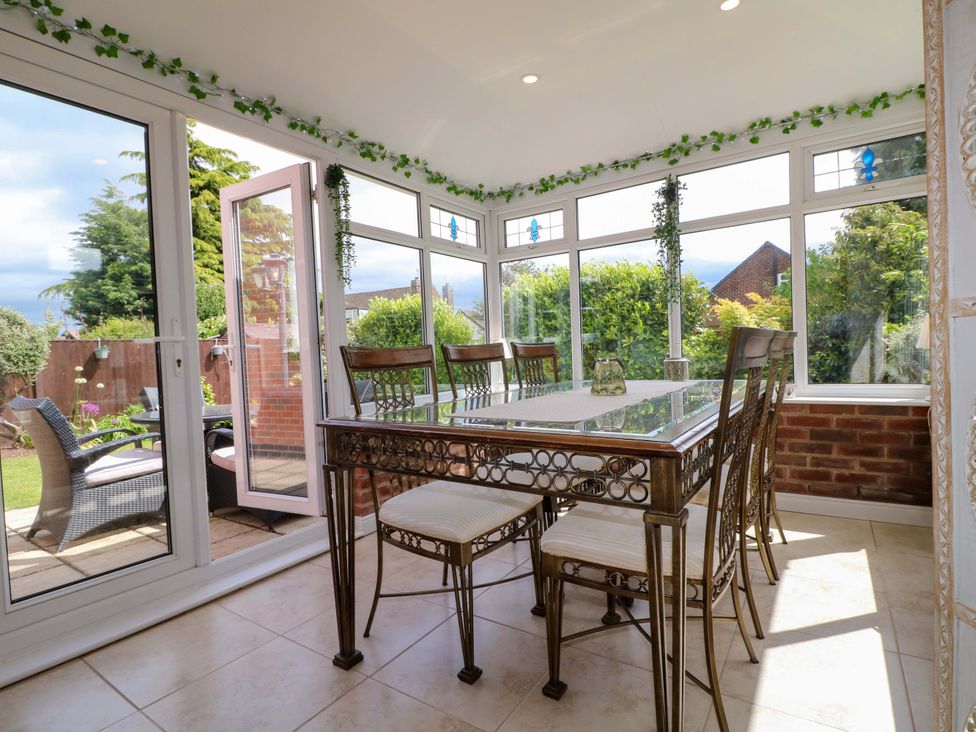 A conservatory with a table and chairs at 16 Temple Crescent Nuthall