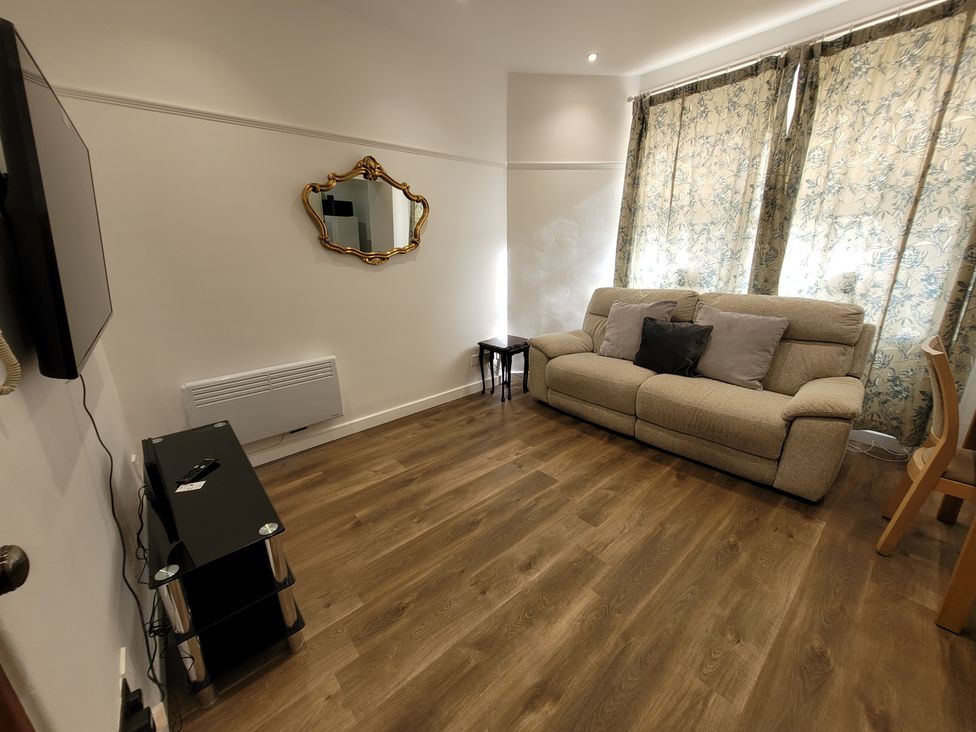 A living room with a sofa and a television at Palace Court