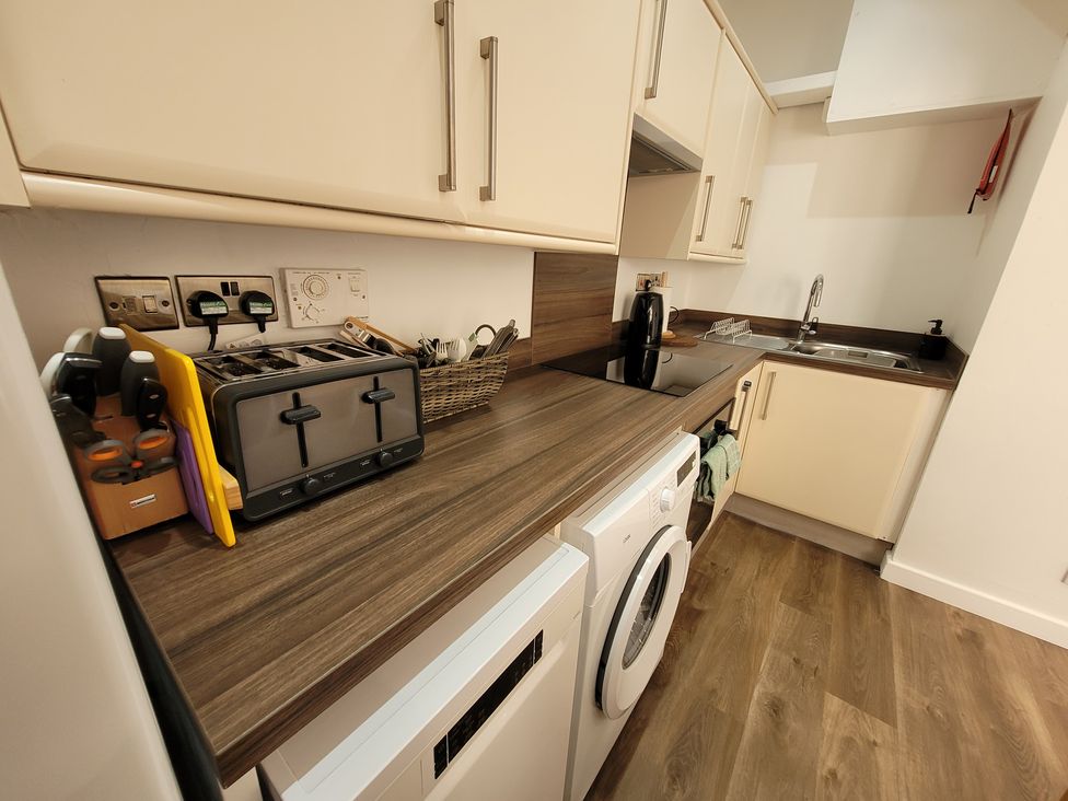 A kitchen with appliances and washing machine at Palace Court