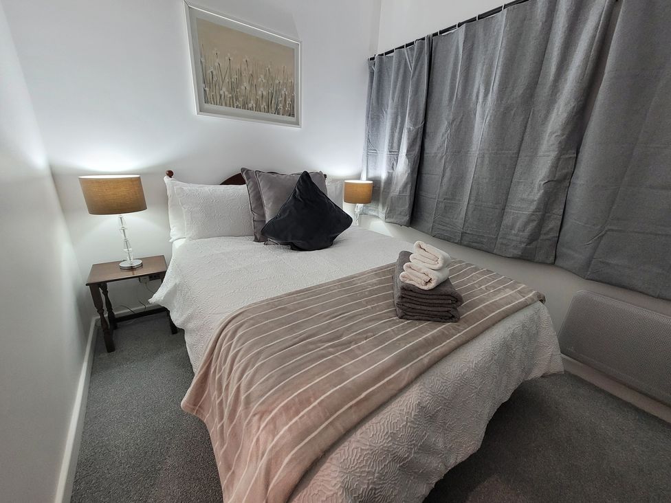 A bedroom with a bed and bedside table at Palace Court