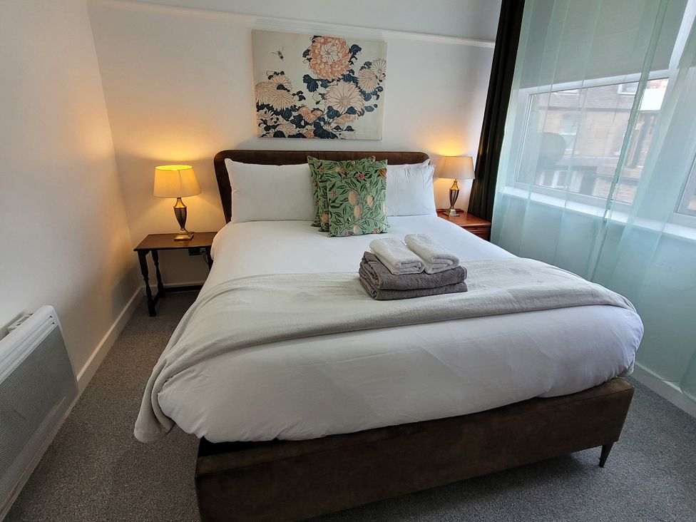 A bedroom with a bed and a bedside table at Palace Court