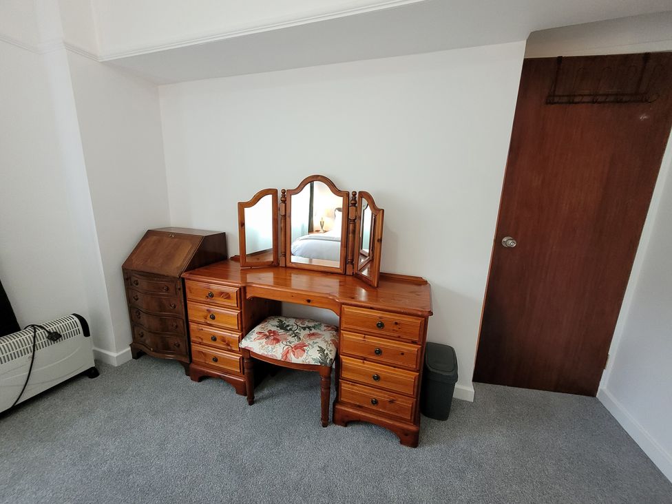 A vanity table with mirrors and drawers in the bedroom at Palace Court 