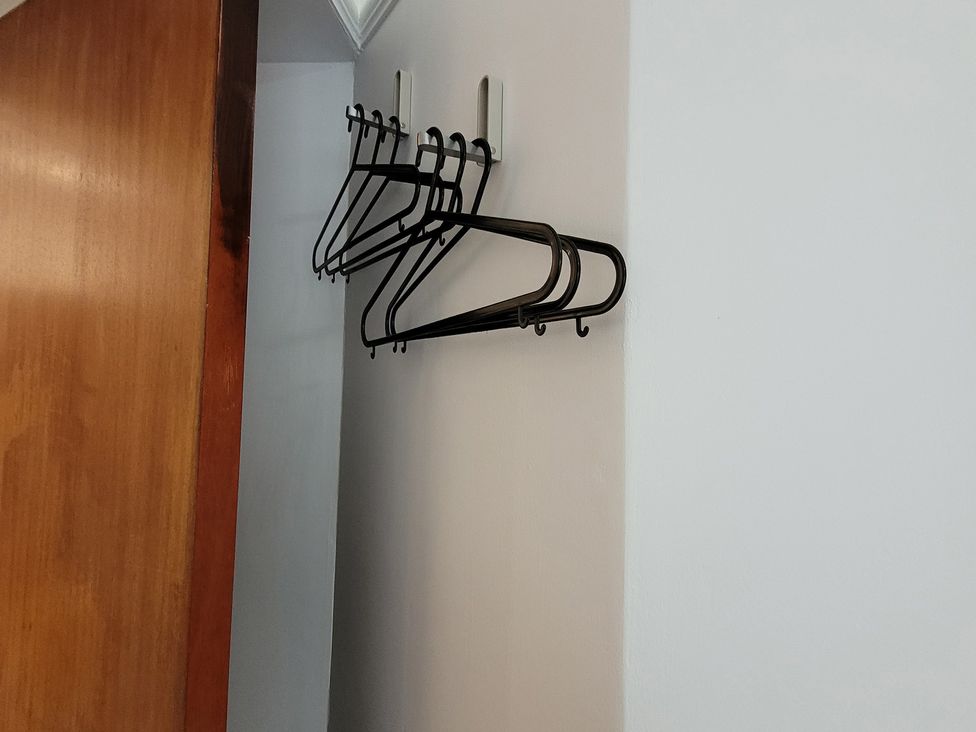 A wall with hangers and a door at Palace Court 