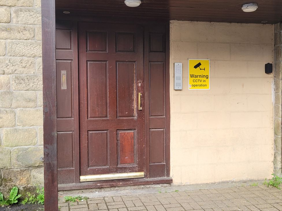 An entrance door with a CCTV warning sign at Palace Court