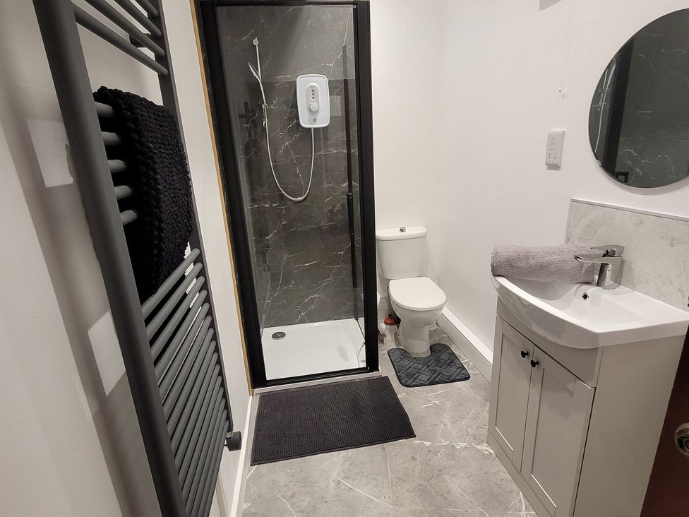 A bathroom with shower, sink, toilet, and towel radiator at Palace Court
