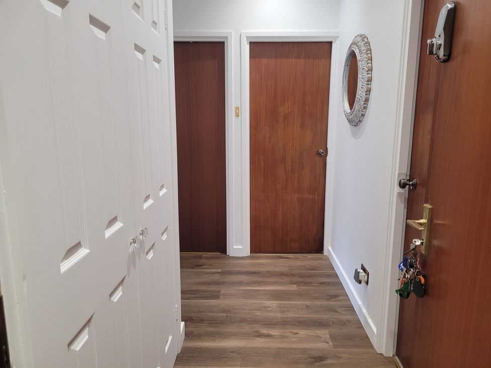 A hallway with doors and a mirror at Palace Court in Buxton