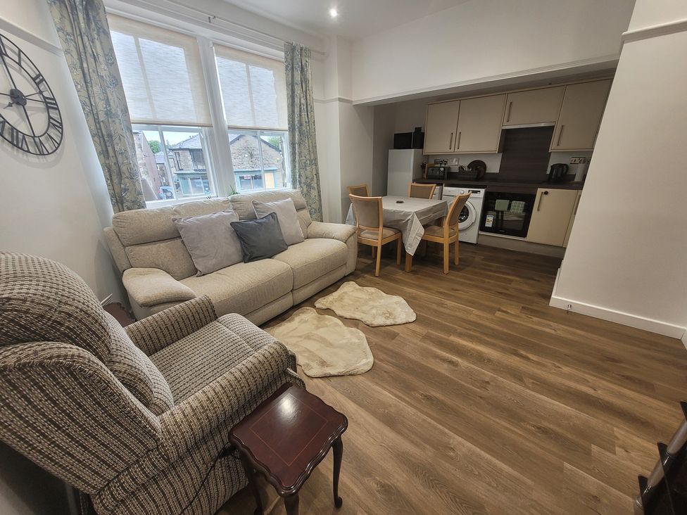 A living room with a sofa and dining area at Palace Court in Buxton