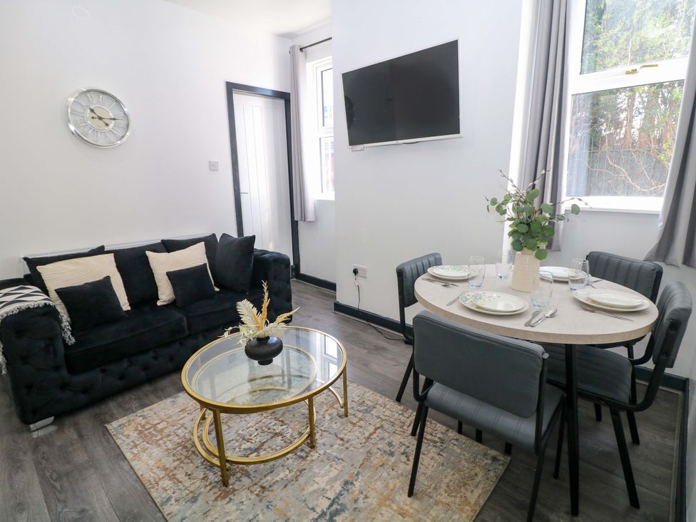 A living room with a sofa, dining area and television at 22 Garfield Street, Stoke-on-Trent
