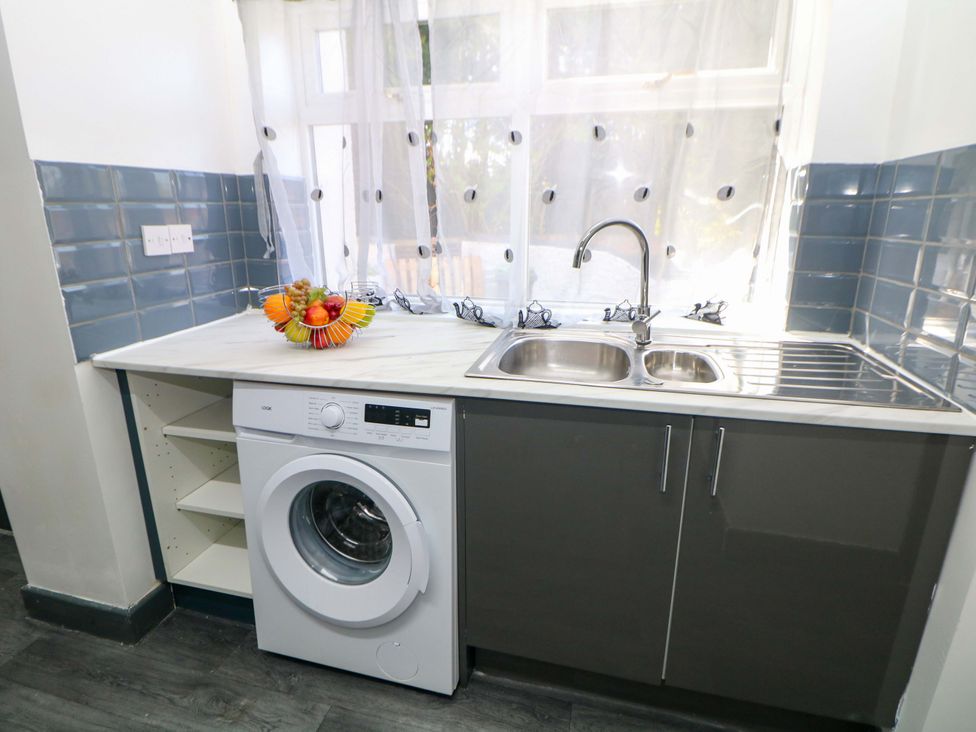 A kitchen with a washing machine and a sink at 22 Garfield Street Stoke-on-Trent