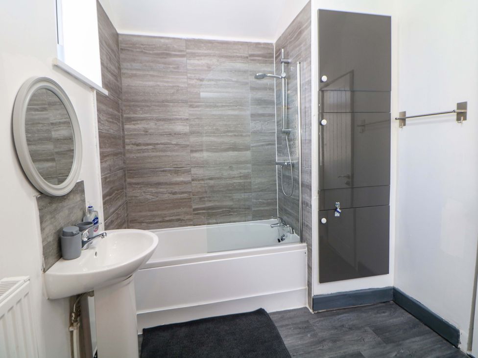 A bathroom with a bathtub, sink, and shower at 22 Garfield Street Stoke-on-Trent