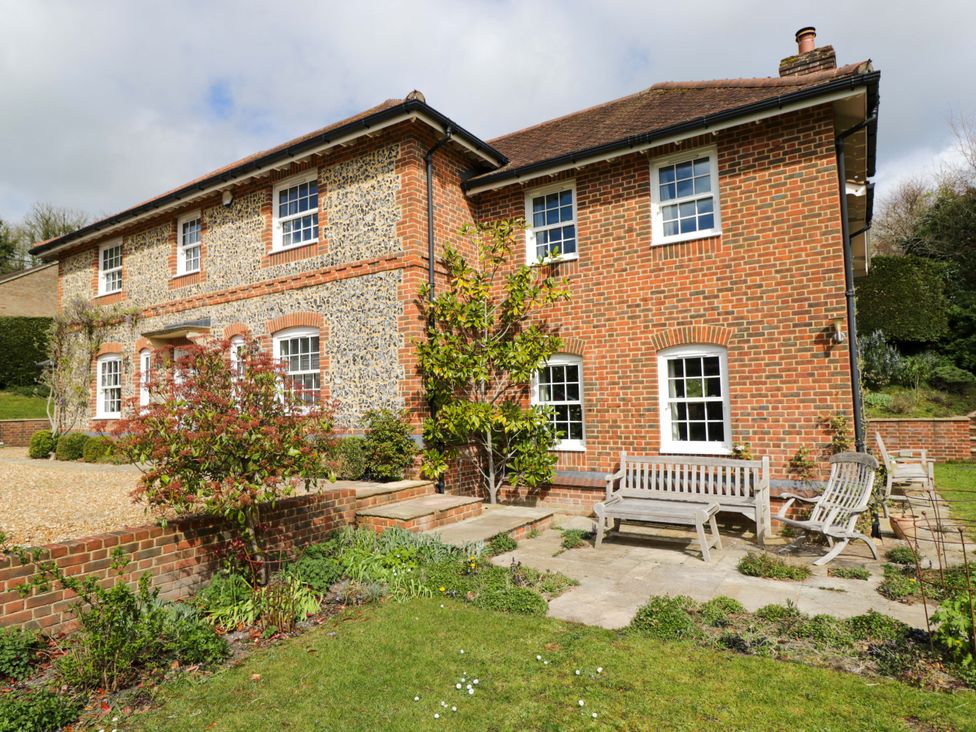 An outdoor area with a house, benches, and a garden at Ormiston House in Netheravon