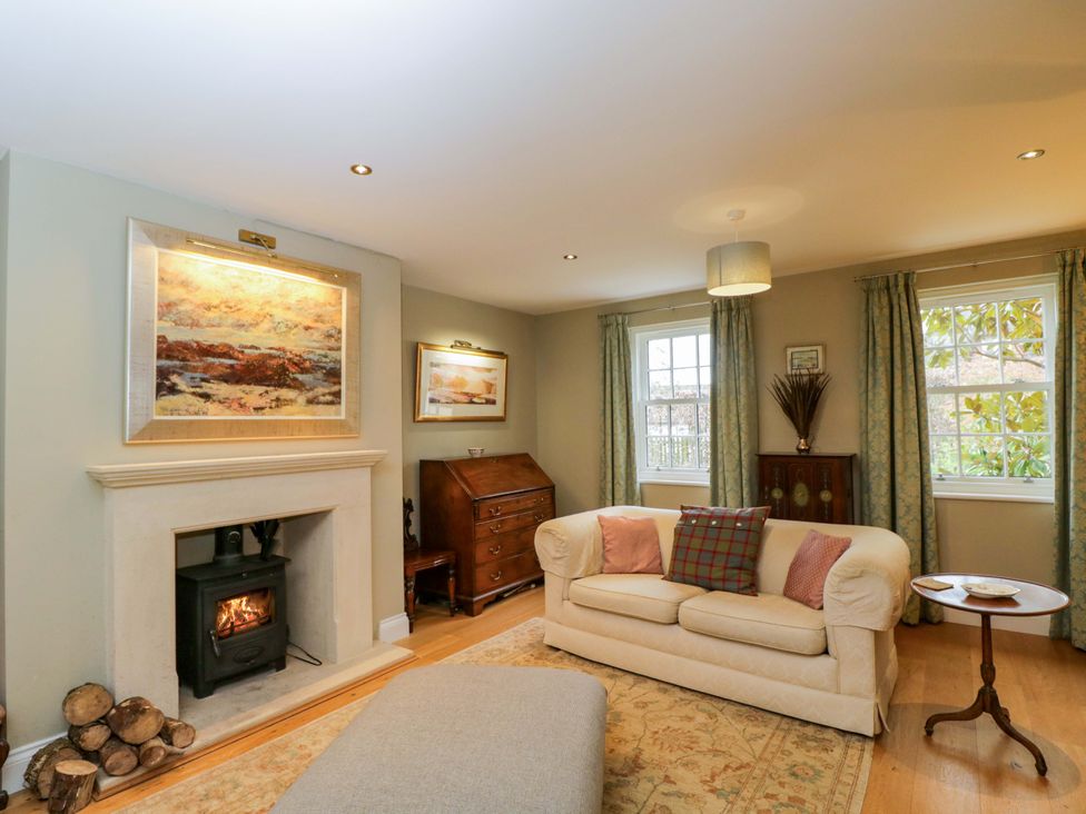 A living room with a fireplace and sofa at Ormiston House in Netheravon