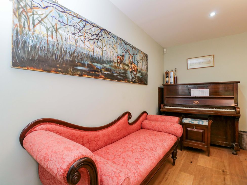 A music room with a couch and a piano at Ormiston House Netheravon