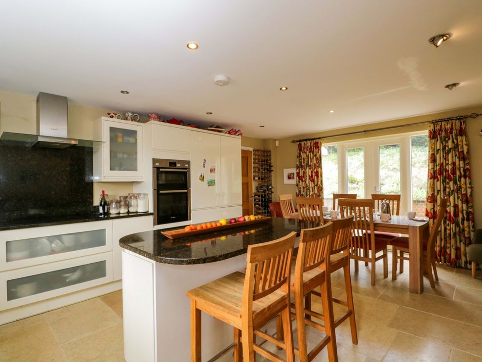 A kitchen with bar stools and dining table at Ormiston House in Netheravon