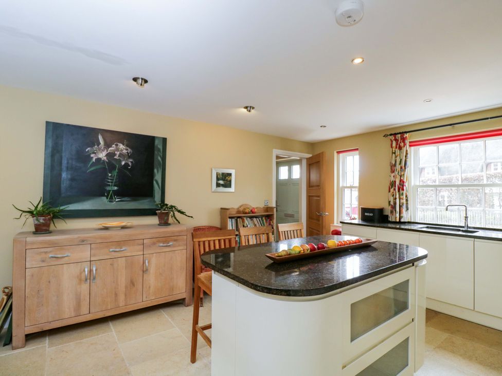 A kitchen with an island and cabinets at Ormiston House in Netheravon