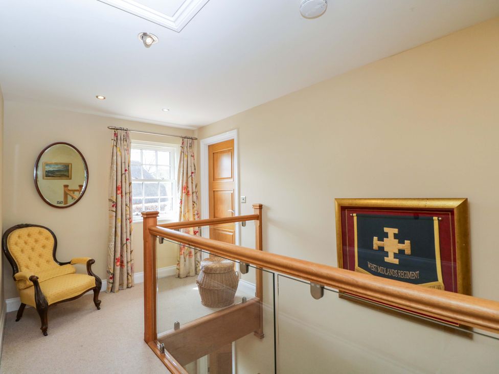 A hallway with a chair and a mirror at Ormiston House Netheravon