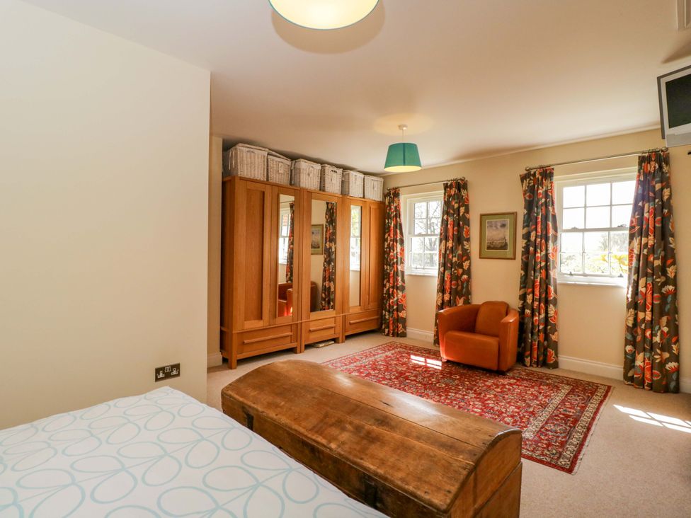 A bedroom with a bed and wardrobe at Ormiston House in Netheravon