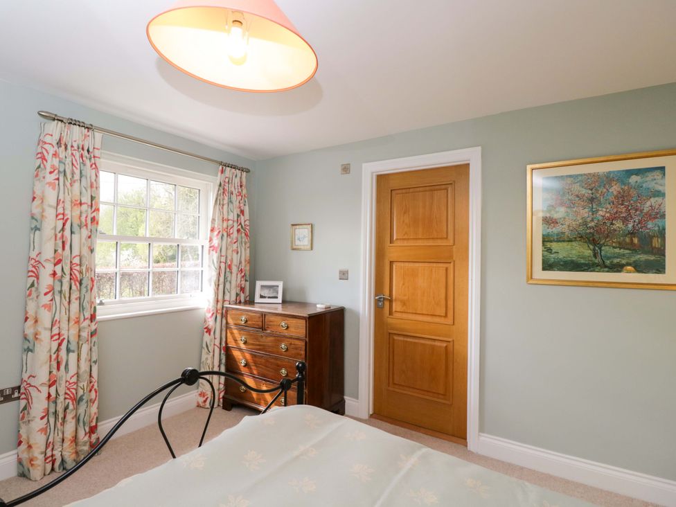 A bedroom with a window and a chest of drawers at Ormiston House, Netheravon