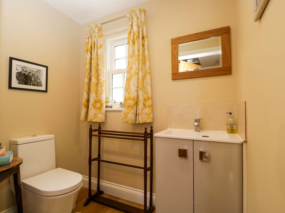A bathroom with toilet, sink, and mirror at Ormiston House in Netheravon