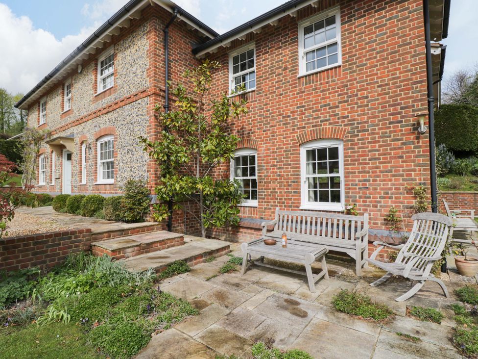 A house exterior with benches and greenery at Ormiston House Netheravon