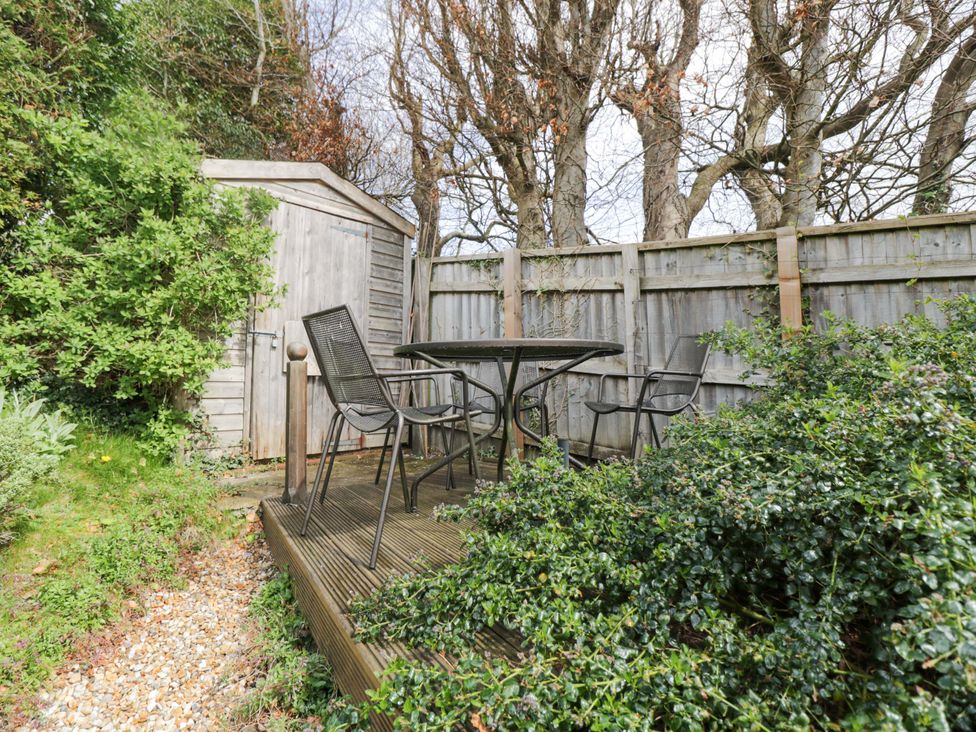 A garden with a table, chairs, and a shed at Ormiston House, Netheravon
