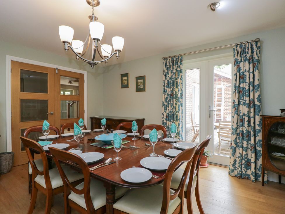 A dining room with a table set for dinner at Ormiston House in Enford near Netheravon