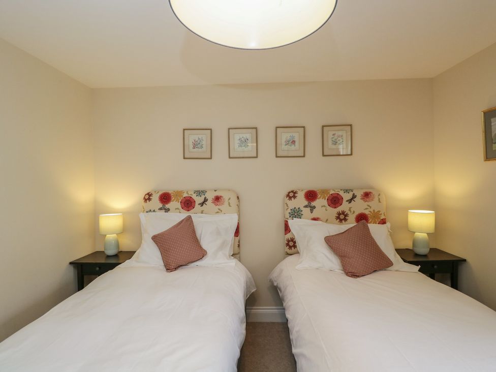A bedroom with two beds and artwork at Ormiston House in Enford near Netheravon