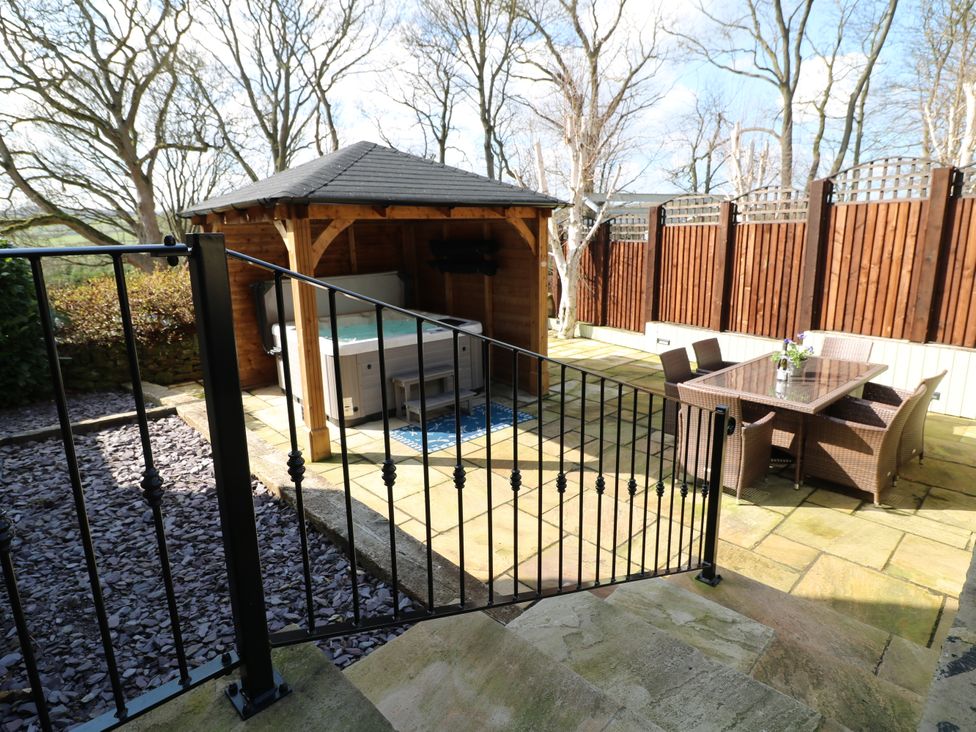 A garden with a hot tub and seating area at Orchard View Oakerthorpe